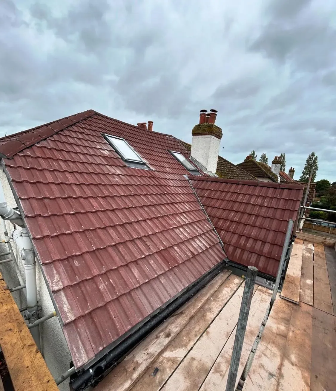 New red tiled roof replacement with Velux windows and scaffolding during installation in Crownhill, Plymouth
