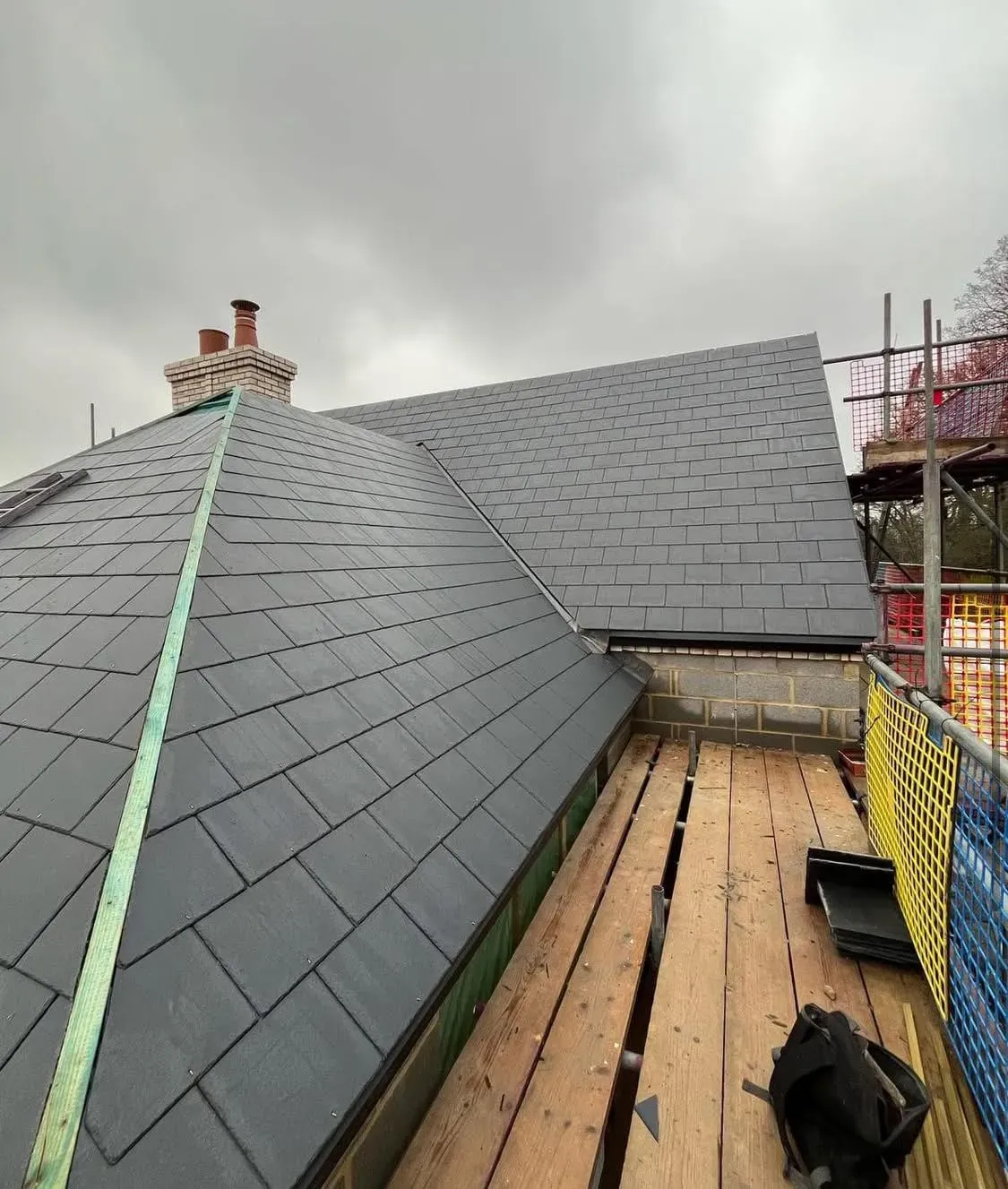 High-quality new slate roof installation with chimney stack and scaffolding by Devon and Cornwall Roofing