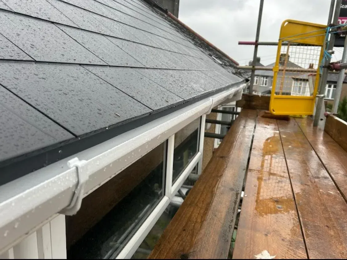 New grey tiled roof installation with white guttering by Devon and Cornwall Roofing.