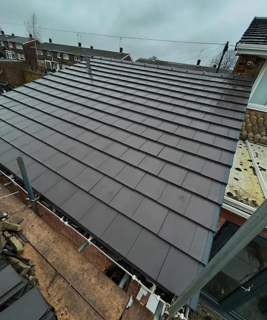 New dark grey tile roof installed on a residential home in Devon or Cornwall by professional roofers, showing a high-quality roof replacement.