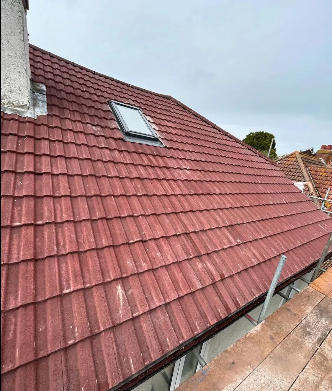 Red tiled roof with a newly installed Velux window, demonstrating expert repair and maintenance